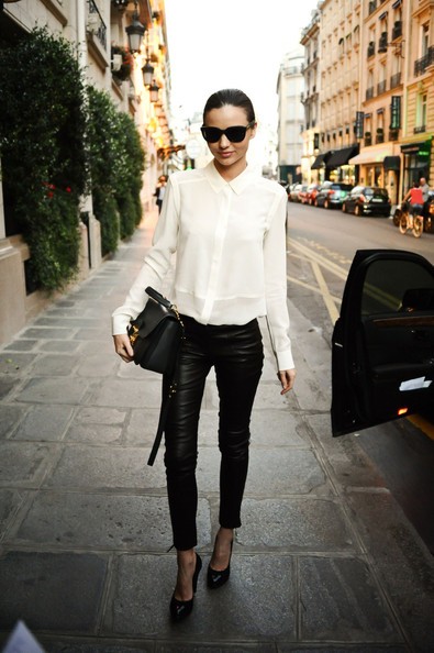 Quần da bó màu đen kết hợp cùng áo sơ mi cực giản dị, Miranda Kerr điểm thêm phụ kiện túi xách, giày và kính cùng tông màu tối khiến cô cực thời trang và phong cách.